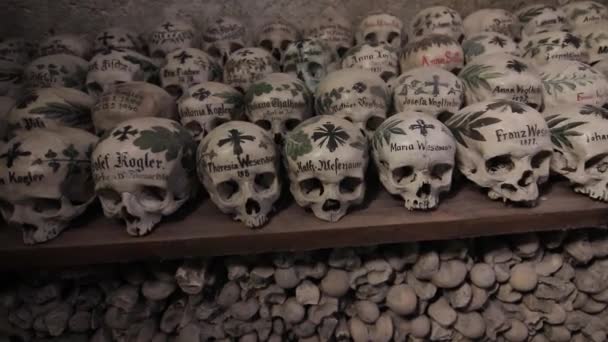 Hallstatt, Áustria Crânios pintados com nomes, flores coloridas e cruzes na Charnel House ou Beinhaus, Hallstatt, Áustria — Vídeo de Stock