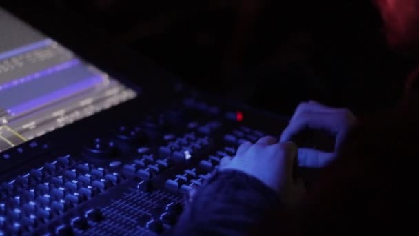 Mesa de mezcla de audio en un concierto. Hombre trabajando en el mezclador de canales de audio digital profesional en el estudio. macho dj manos jugando set en noche club partido cámara lenta — Vídeos de Stock