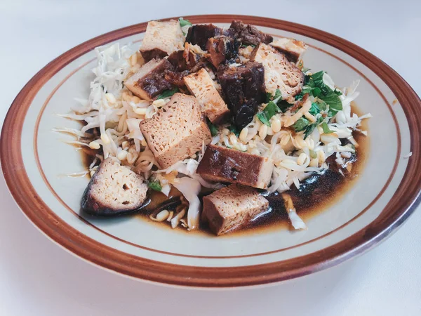 Merkezi Cava 'nın Solo şehrinin geleneksel Endonezya yemekleri olan Tahu Kupat Solo, kızarmış tofu, fasulye filizi, dilimlenmiş lahana, dilimlenmiş bakwan, sarı erişte ve kızarmış fıstıktan oluşur.