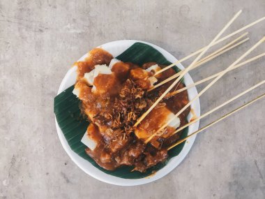 Beyaz tabakta etli ve soslu tavuk, yakın görüş. 