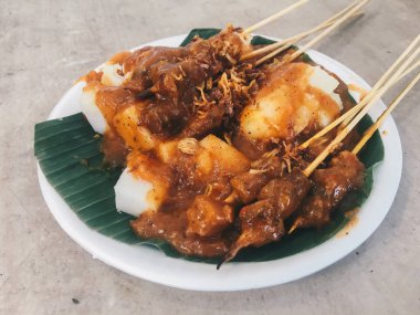 Beyaz tabakta etli ve soslu tavuk, yakın görüş. 