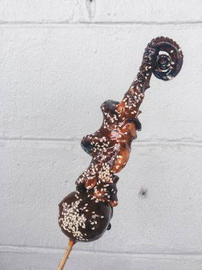 Ahşap bir şişte kızarmış mürekkep balığı, yakın görüş.