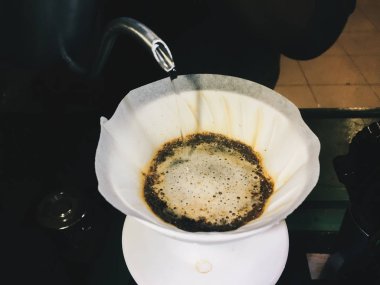 Demlikten şişeye, filtrede kahveyle kaynar su dök.