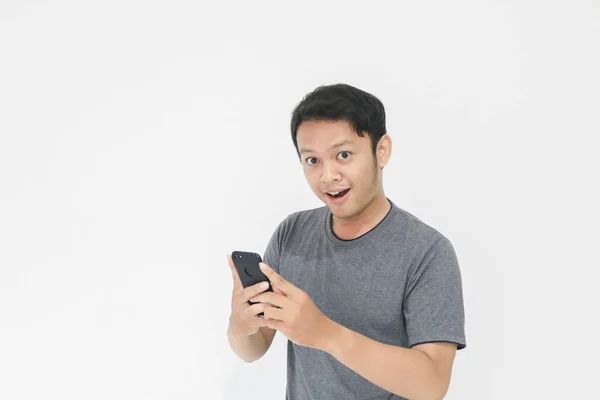 Engraçado Asiático Homem Cinza Shirt Usando Smartphone Gestos Enquanto Posando — Fotografia de Stock