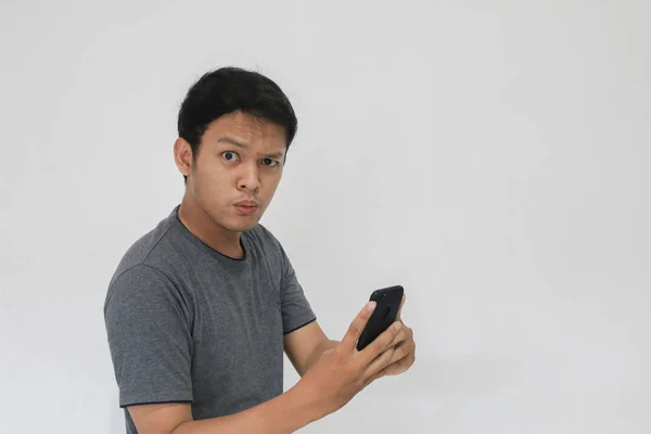 Divertente Asiatico Uomo Grigio Shirt Utilizzando Smartphone Gesturing Mentre Posa — Foto Stock