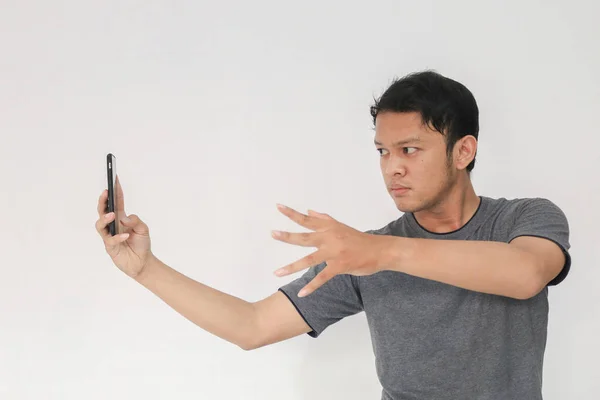 Divertido Asiático Hombre Gris Camiseta Usando Smartphone Gesto Mientras Posando —  Fotos de Stock