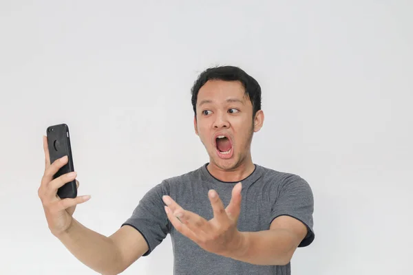 Divertido Asiático Hombre Gris Camiseta Usando Smartphone Gesto Mientras Posando —  Fotos de Stock