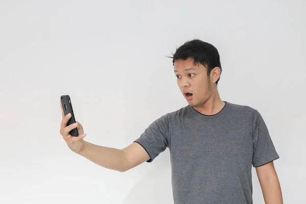 Zabawny Azjata Mężczyzna Szarym Shirt Pomocą Smartfona Gestykulując Podczas Pozowania — Zdjęcie stockowe