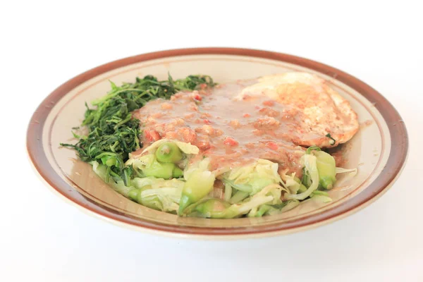 Stewed meat with vegetables, herbs and fried egg.