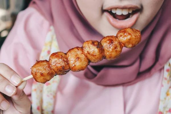Close view of muslim woman eating meatballs