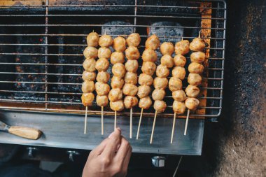 Izgarada köfte pişiren kişi.