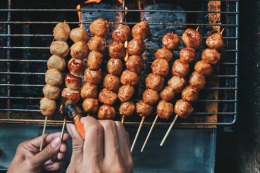 Izgarada köfte pişiren kişi.