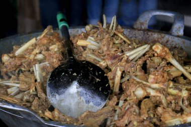 İştah açıcı kızarmış et ve büyük bir tencerede pişen kemikler.