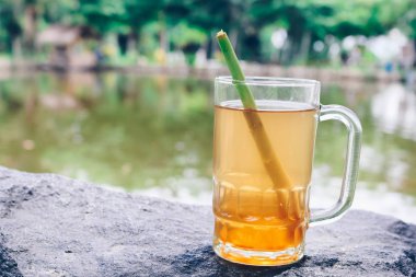 Kocaman bir taşın üzerinde duran bir bardak limonata.