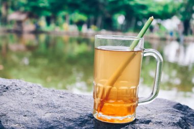 Kocaman bir taşın üzerinde duran bir bardak limonata.