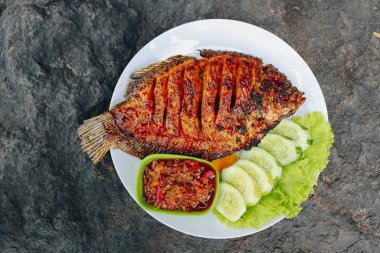 Baharatlı soslu ızgara balık ve salatalık.