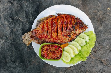 Baharatlı soslu ızgara balık ve salatalık.