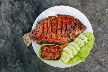 Baharatlı soslu ızgara balık ve salatalık.