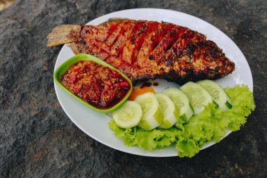 Baharatlı soslu ızgara balık ve salatalık.