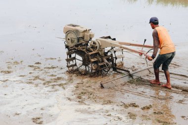 Çiftçi adam toprakta çalışıyor.