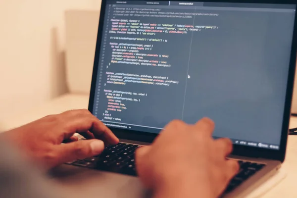 dizüstü bilgisayarda klavyede yazan adam.  