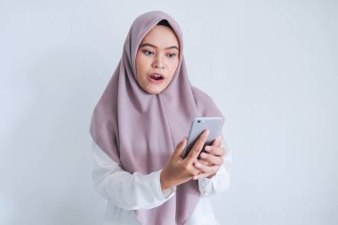 Şaşırmış kız cep telefonuyla görüntülü konuşma yapıyor. 