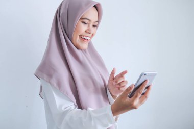 Gülümseyen kız cep telefonuyla görüntülü konuşma yapıyor. 