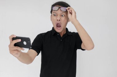 Siyah tişörtlü Asyalı genç şoka uğramış.