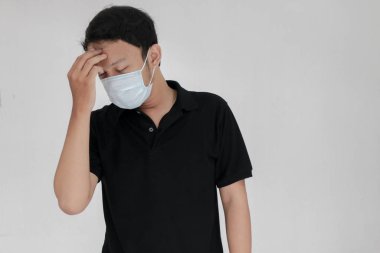 Maskeli genç Asyalı acı çekiyor.