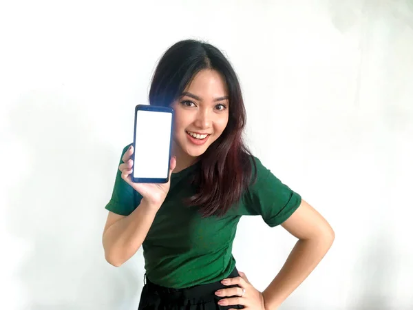 身穿绿色T恤 手持手机的亚洲女人 — 图库照片