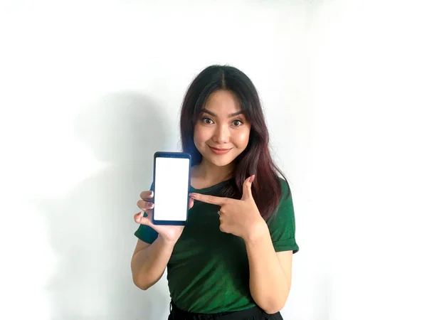 Cep telefonu olan yeşil tişörtlü mutlu Asyalı kadın.