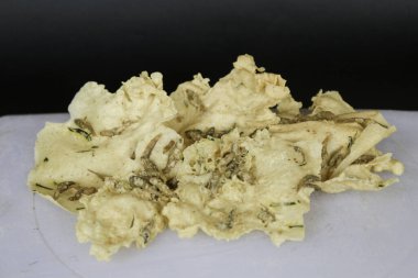 Rempeyek ya da ahşap tabakta tuzlu balıklı balık krakerleri veya arka planda izole edilmiş ikan teri. Çıtır un karışımı ile tuzlanmış balıklı pirinç unundan yapılmış kızarmış lezzetli Java krakerleri..