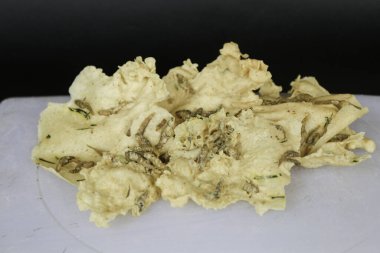 Rempeyek ya da ahşap tabakta tuzlu balıklı balık krakerleri veya arka planda izole edilmiş ikan teri. Çıtır un karışımı ile tuzlanmış balıklı pirinç unundan yapılmış kızarmış lezzetli Java krakerleri..