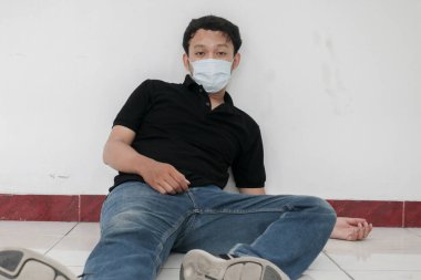 Maskeli genç Asyalı acı çekiyor.