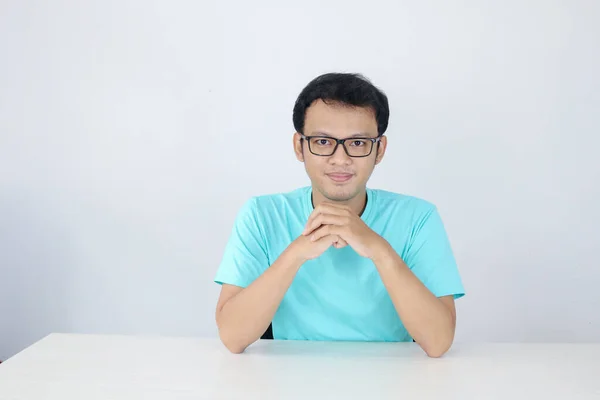 아시아인 청년은 셔츠와 안경을 행복하게 손으로 테이블에 — 스톡 사진