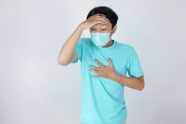 医療マスクを使用して病気の若いアジア人男性は 手のタッチ胸と額とインフルエンザや頭痛です コロナウイルス インフルエンザ 痛みの概念 — ストック写真