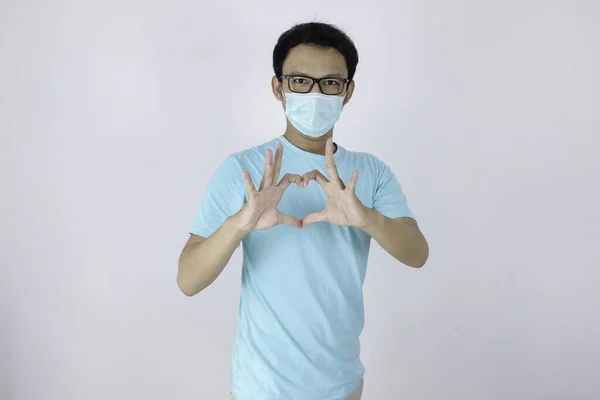 질병으로부터 보호하기 마스크를 아시아 남자는 사랑의 표시를 배경은 격리되어 코로나 — 스톡 사진