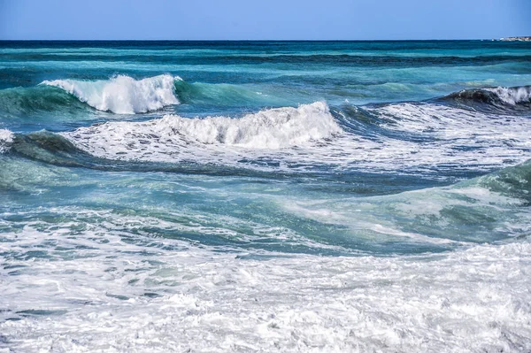 新鮮な春の風がキプロスの海岸に波を駆動します 地中海は暗いウルトラマリンと内側からの明るい紺碧で描かれています — ストック写真
