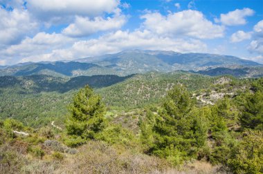 Hafif bulutlar Troodos Dağları 'nın tepe ve yamaçlarına gölgeler düşürür. Gölgeler dağdan dağa sürünüyor, şekillerini değiştiriyor..         