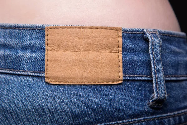 Empty leather label and jeans — Stock Photo, Image