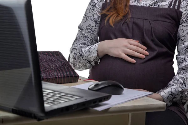 Schwangere umarmt Bauch bei der Arbeit — Stockfoto