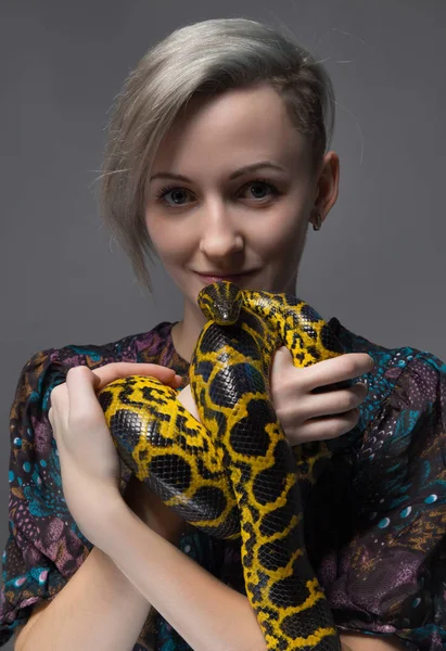 Young woman holding yellow anaconda — Stock Photo, Image