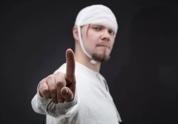 Man with bandaged head showing forefinger — Stock Photo, Image