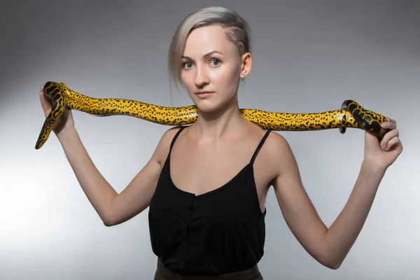 Woman stretching yellow snake — Stock Photo, Image