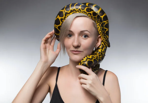 Blond woman and snake on her head — Stock Photo, Image