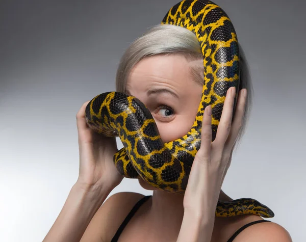 Donna bionda e strangolamento anaconda gialla — Foto Stock
