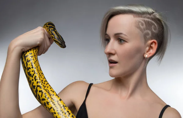 Giovane donna in possesso di serpente giallo — Foto Stock