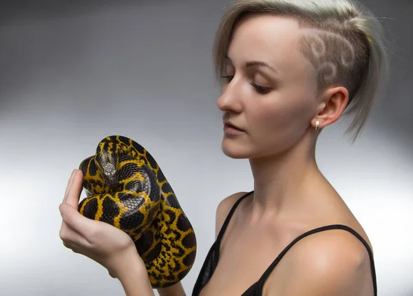 Ξανθιά γυναίκα εκμετάλλευση κίτρινο anaconda — Φωτογραφία Αρχείου