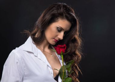 Kırmızı gül tutan esmer kıvırcık kadın