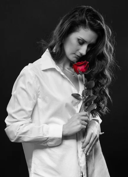 Donna riccia con rosa rossa in mano — Foto Stock